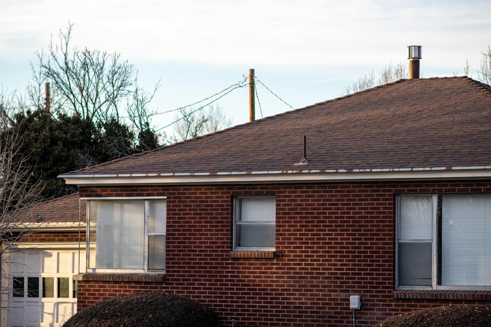 Roofing crew on a sunny day mid-install, the kind of working scene that should anchor a roofing website's visual proof
